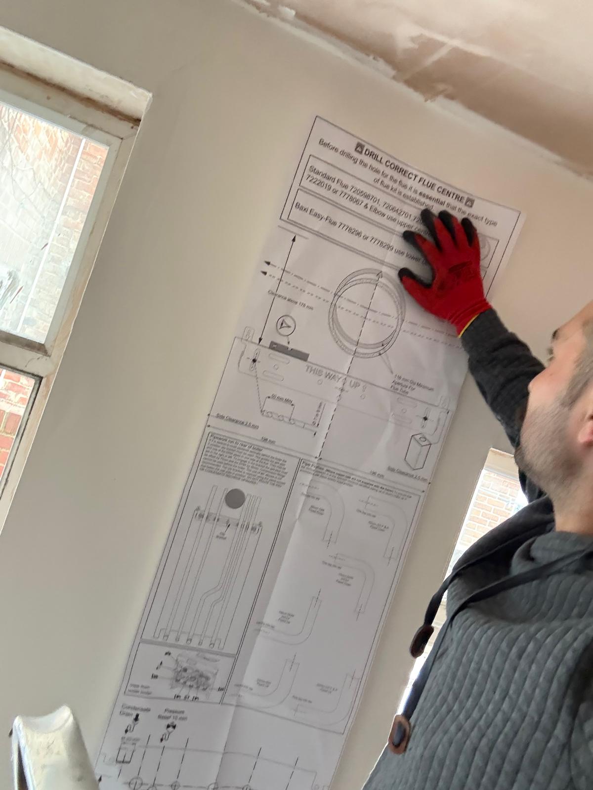 Engineer positioning a boiler installation template